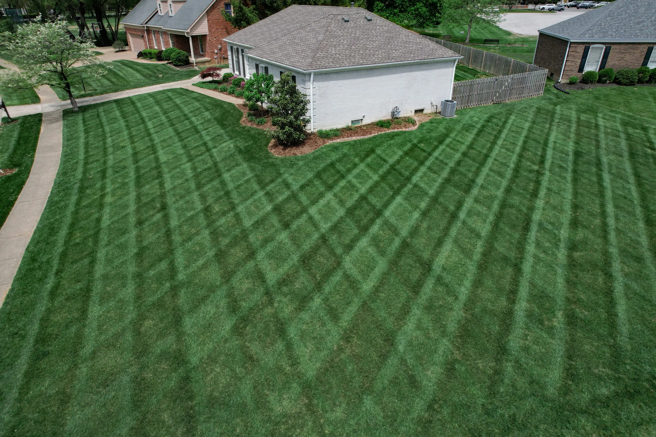 The Fransen Group neatly mowing a residential lawn in a crossing pattern