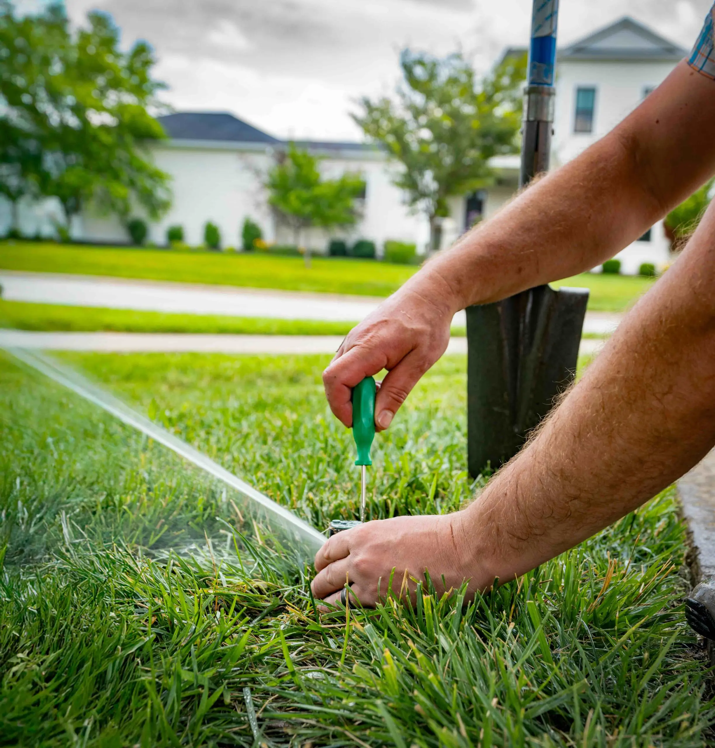 Irrigation sprinkler system being adjusted by a professional from The Fransen Group Landscaping Company