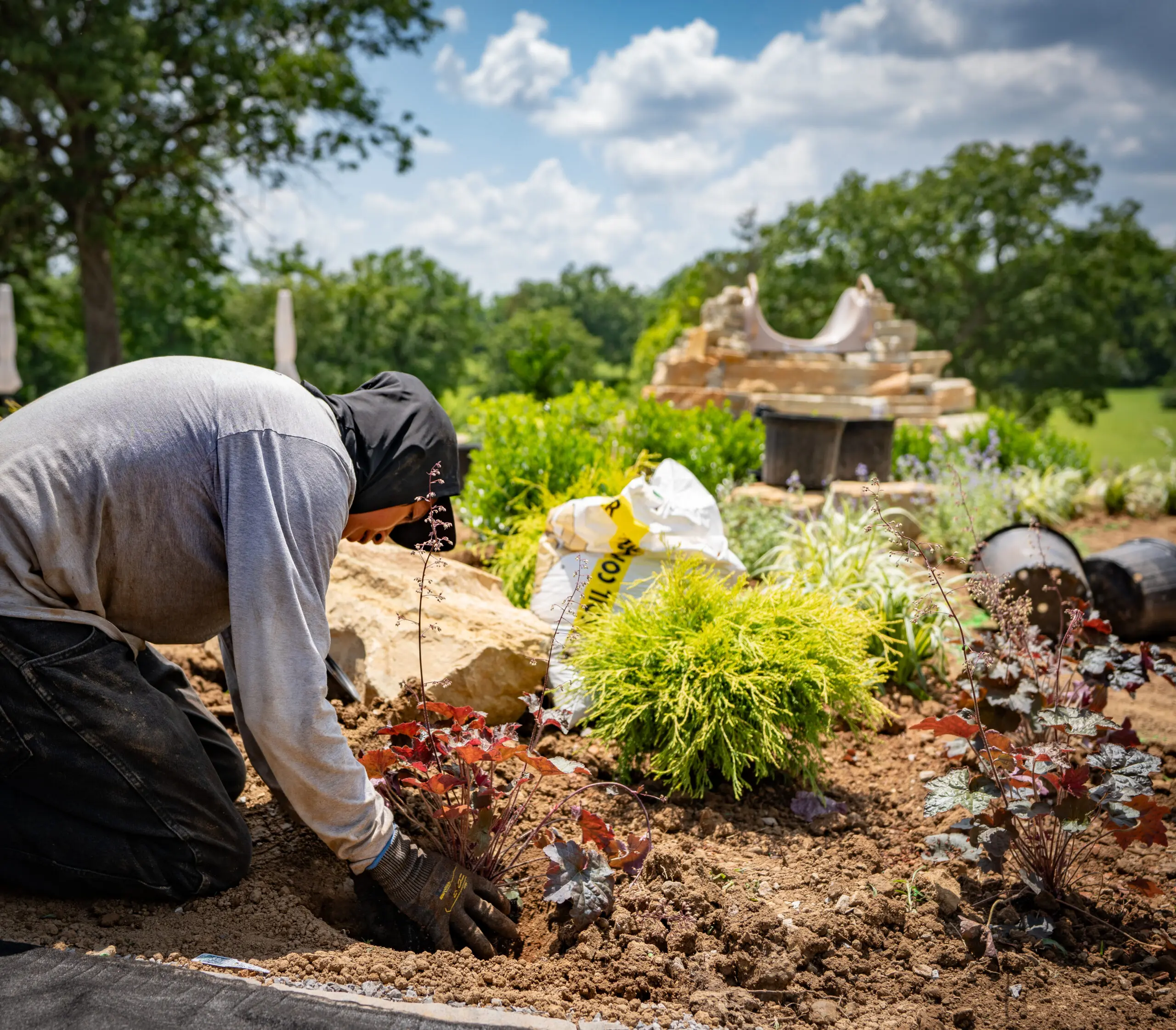 The Fransen Group planting and organiznig plants and enchancing a lawn bed