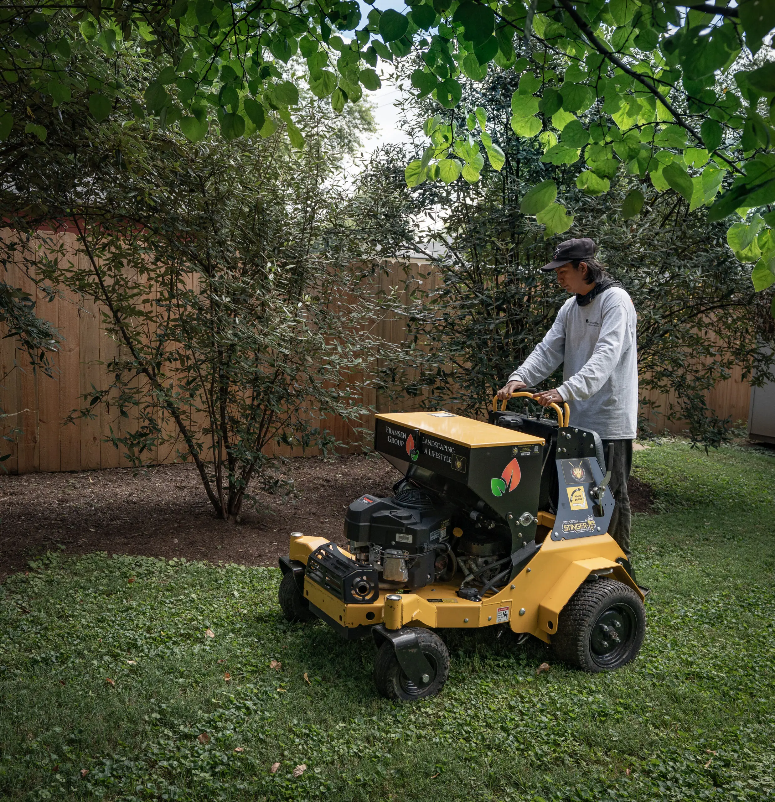 The Fransen Group Landscaping Company using a lawn machine to rejuvinate and tidy up a residential lawn.