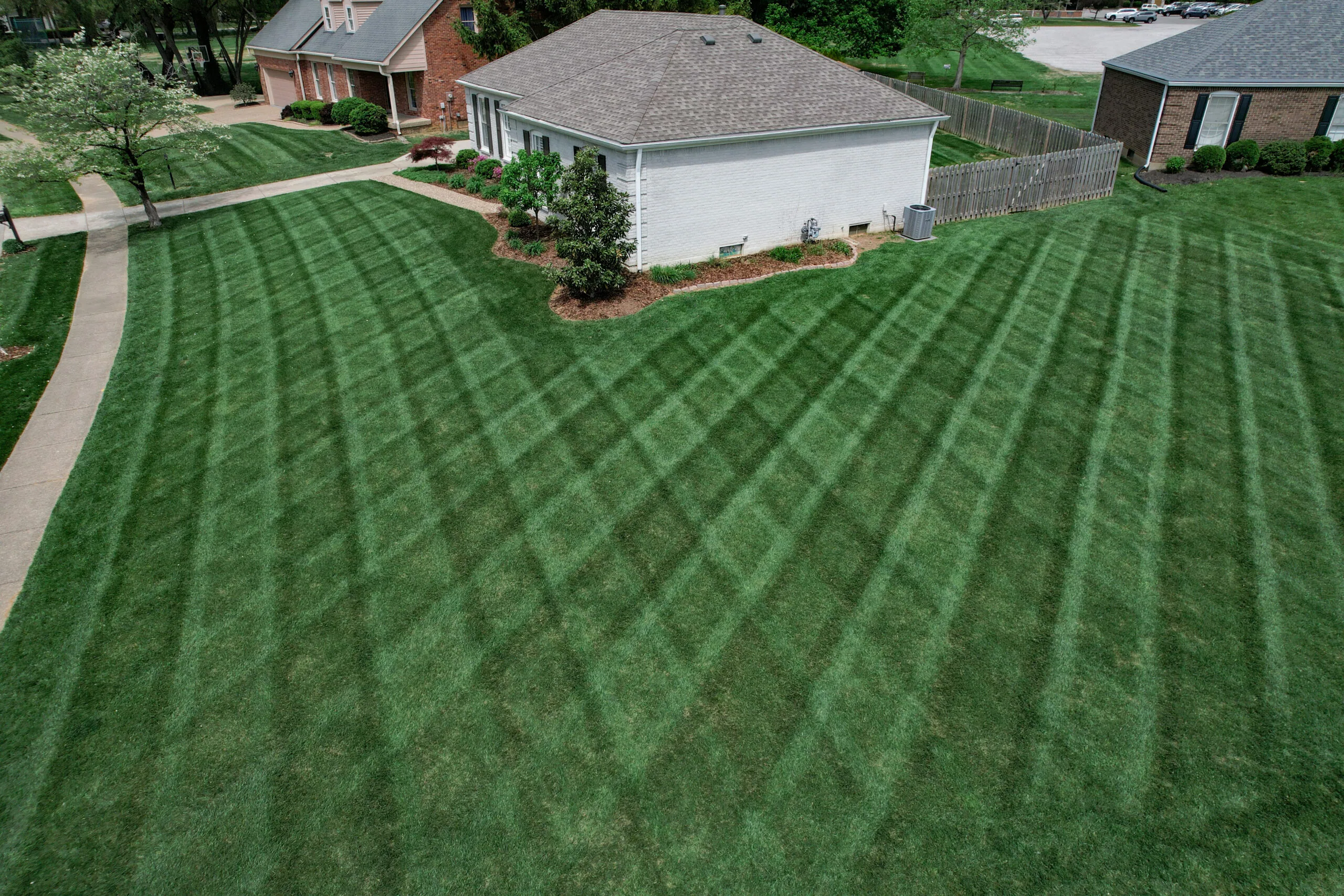 The Fransen Group neatly mowing a residential lawn in a crossing pattern