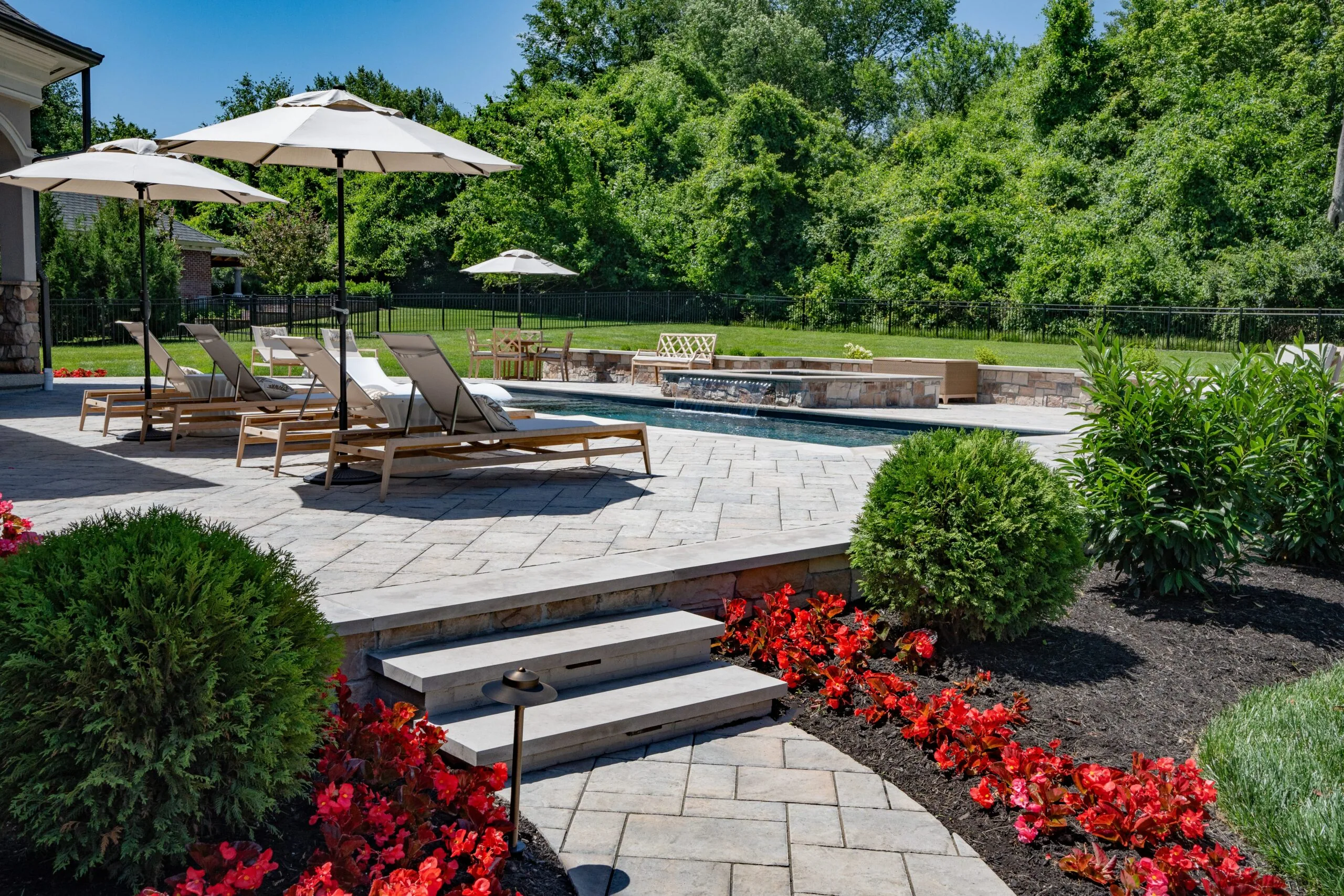 Beautifully designed residential landscape with lush greenery and a modern patio in Louisville, KY.