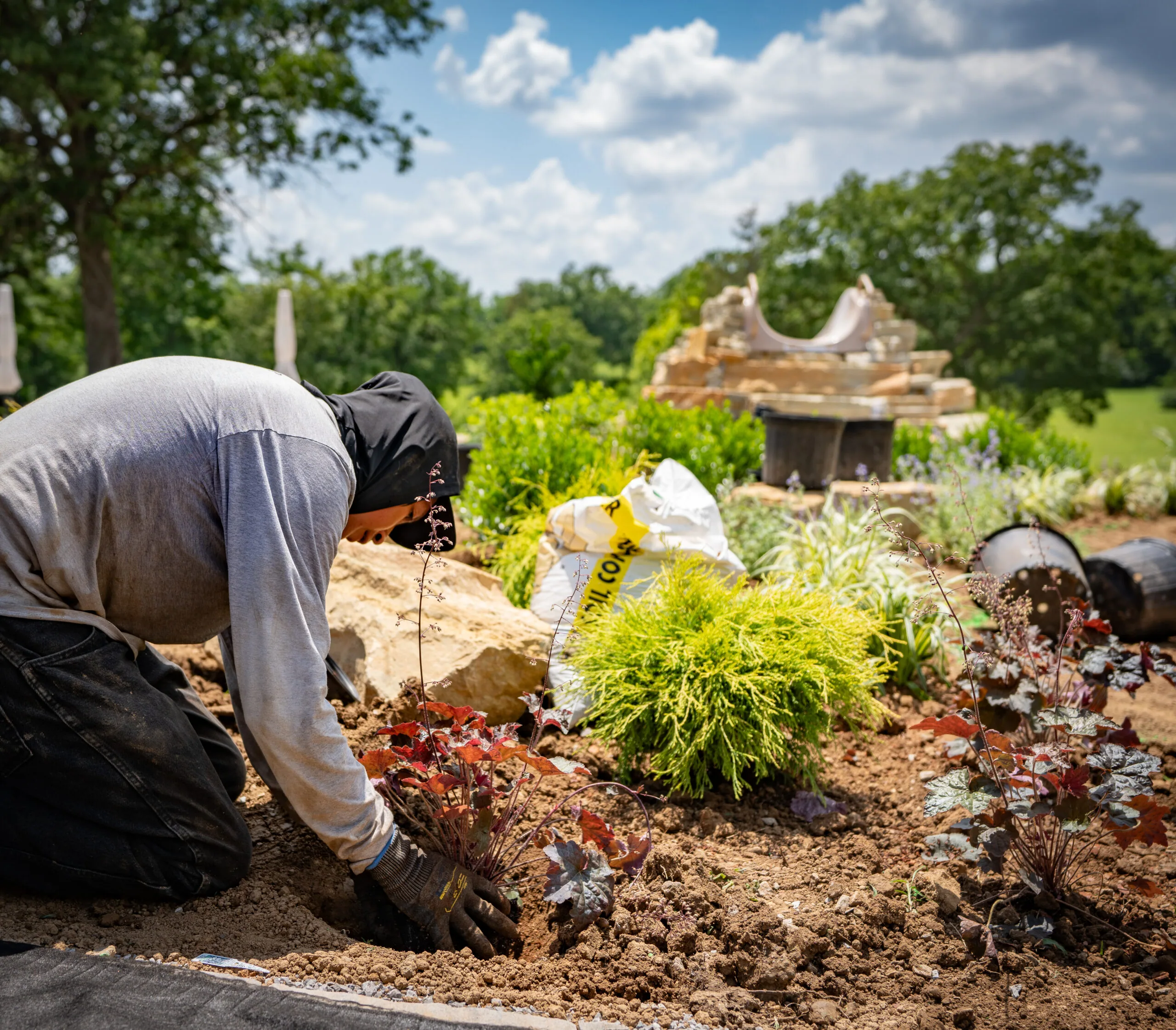 The Fransen Group planting and organiznig plants and enchancing a lawn bed