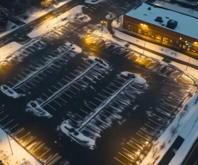 A snow cleared parking lot in an office complex setting.